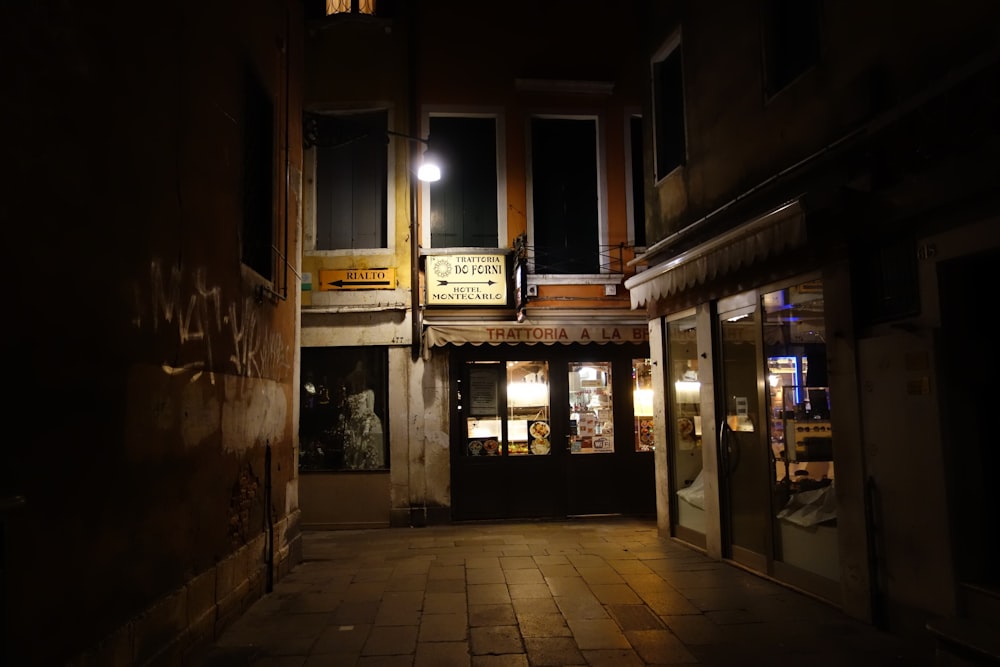 a dimly lit street at night with a store front