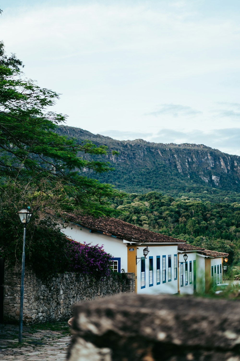 a white house with a mountain in the background