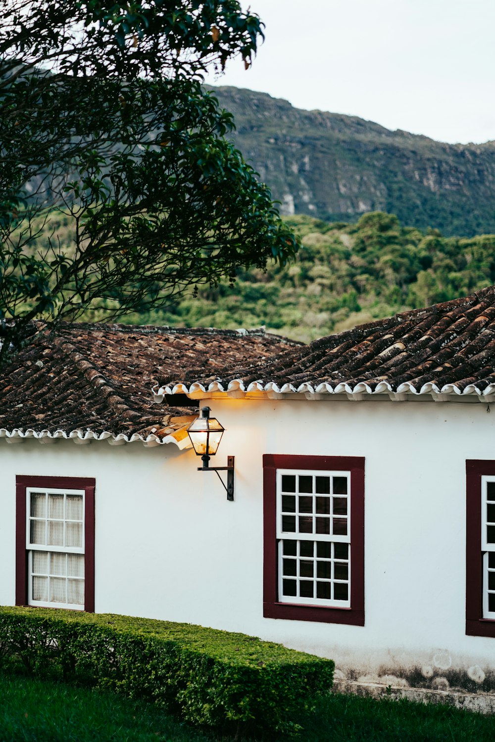 a white house with red shutters and a brown roof