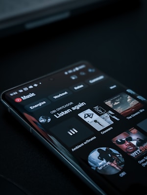 A smartphone screen displaying a music streaming app interface. The screen shows music categories such as Energize, Relax, and a 'Listen again' section with album covers.