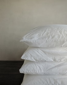a stack of pillows sitting on top of a wooden table