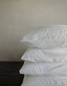 a stack of pillows sitting on top of a wooden table