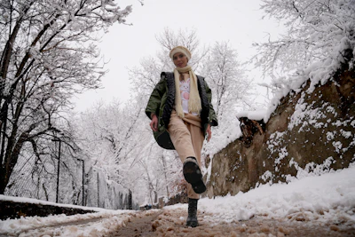 a woman walking down a snow covered road