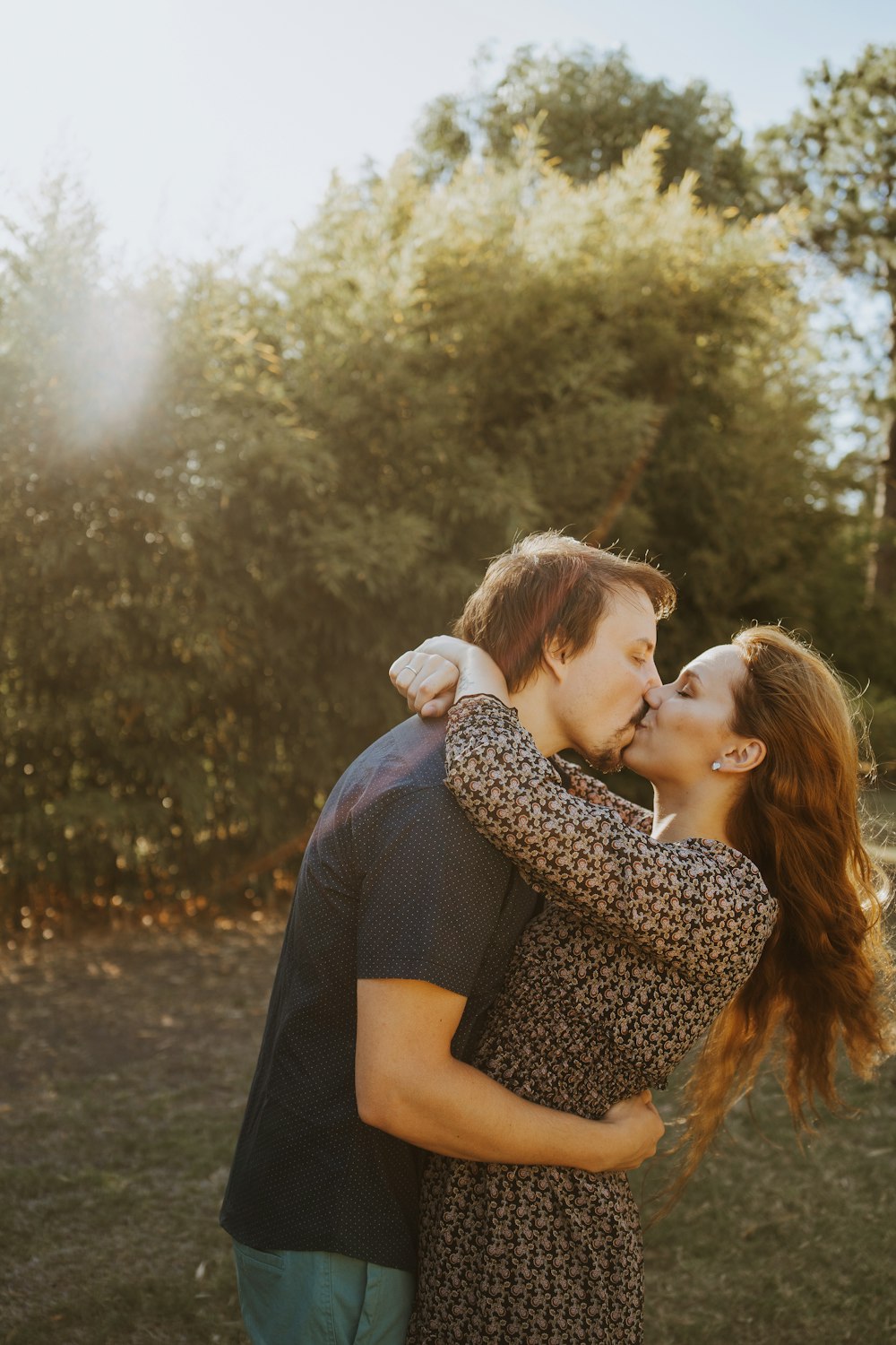 um homem e uma mulher se beijando em um campo