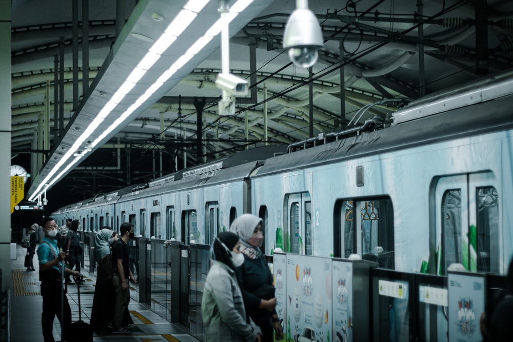 a group of people standing next to a train