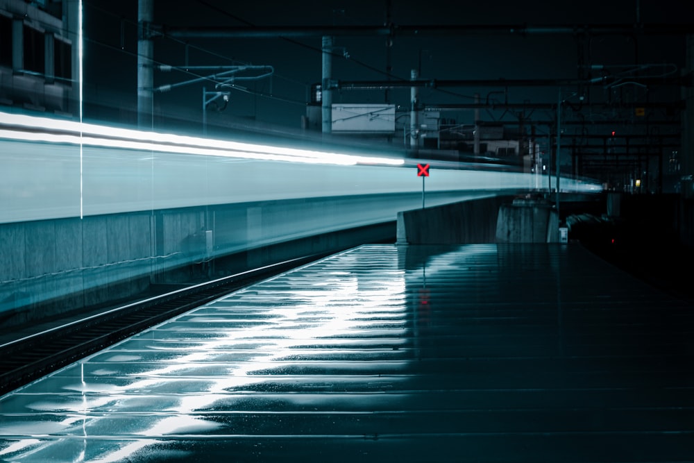 a train traveling down train tracks next to a loading platform