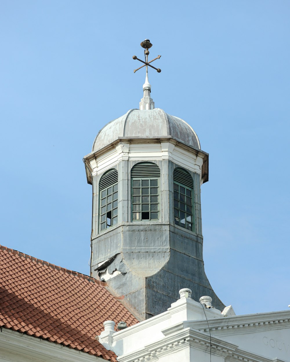 a tall white building with a cross on top of it