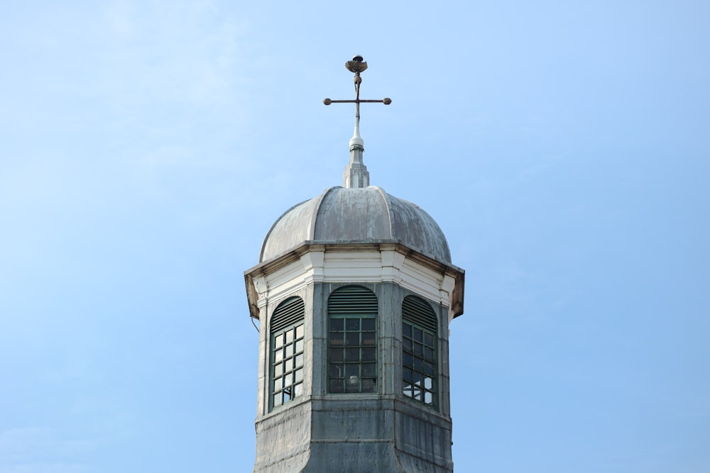 una torre alta con una cruz encima