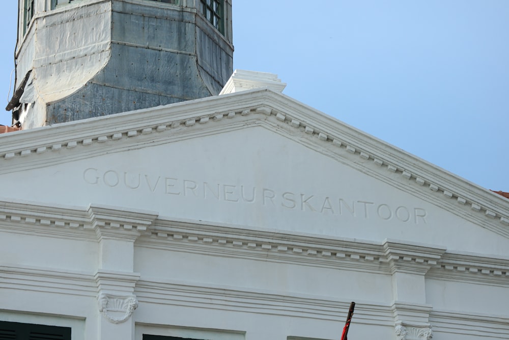 a white building with a clock tower in the background