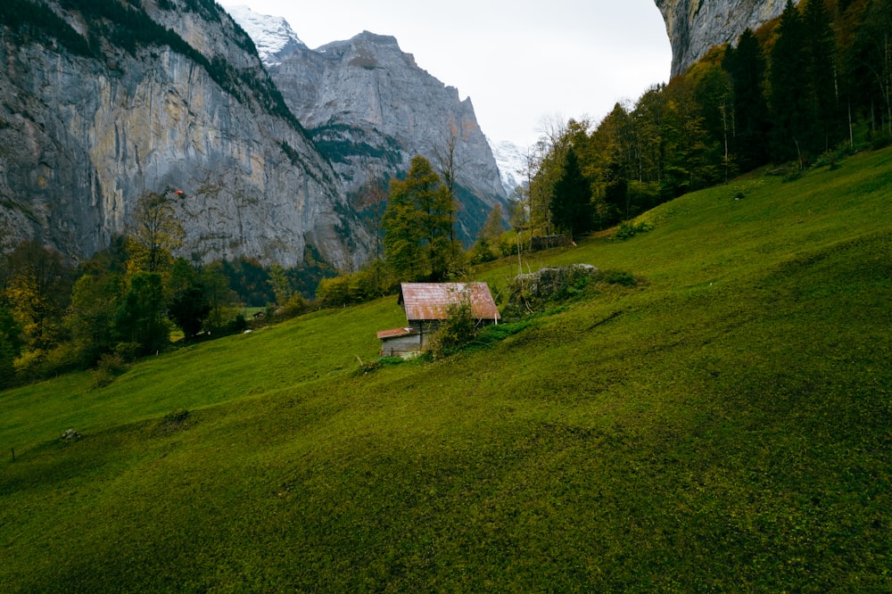 a small house sitting on top of a lush green hillside