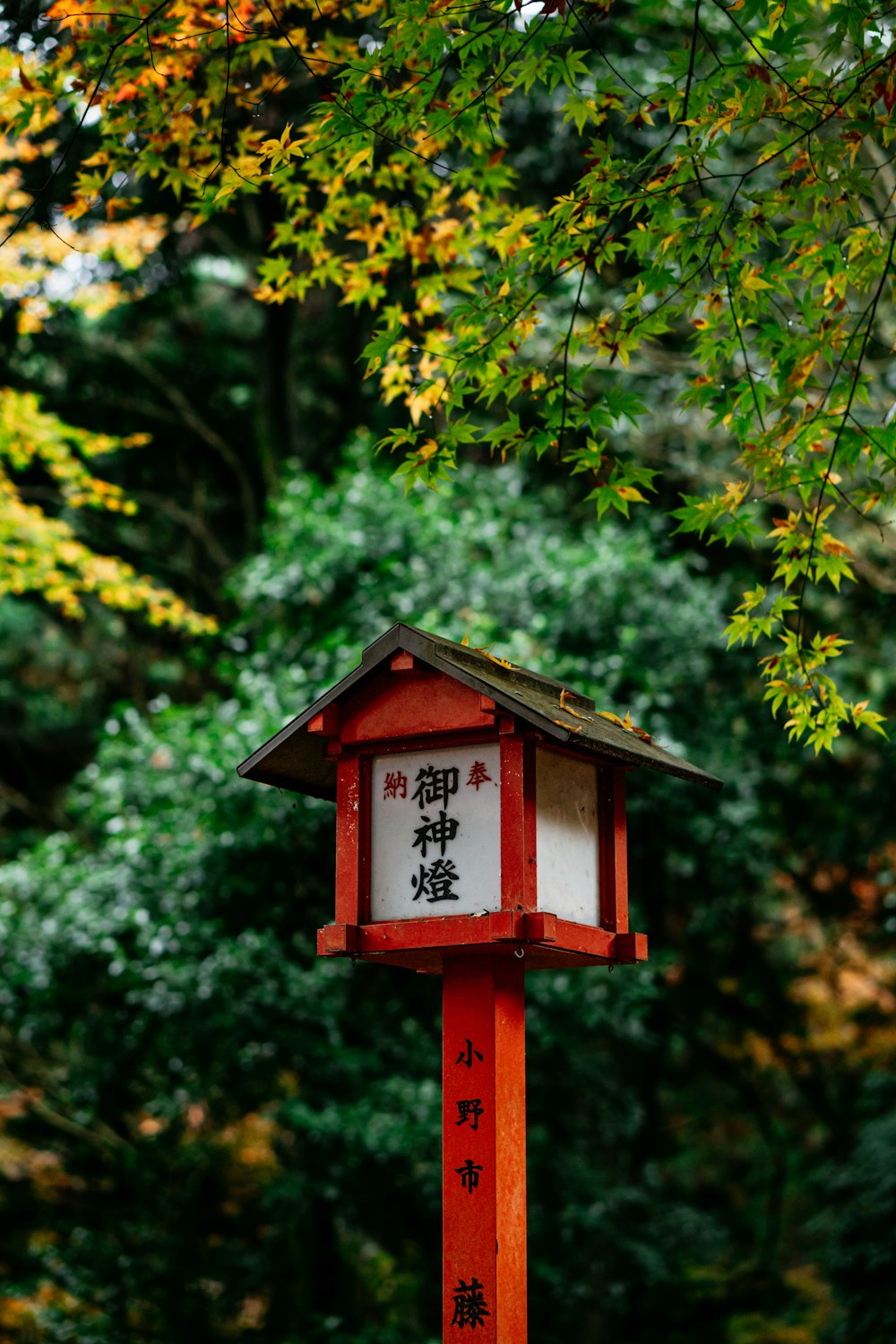 a red and white bird house with asian writing on it