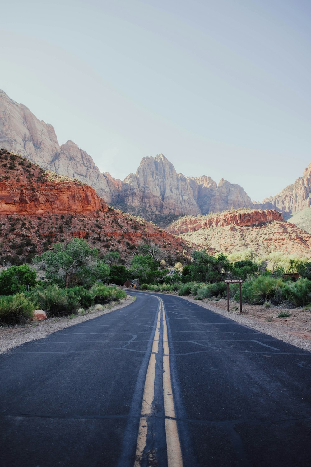 an empty road with mountains in the background