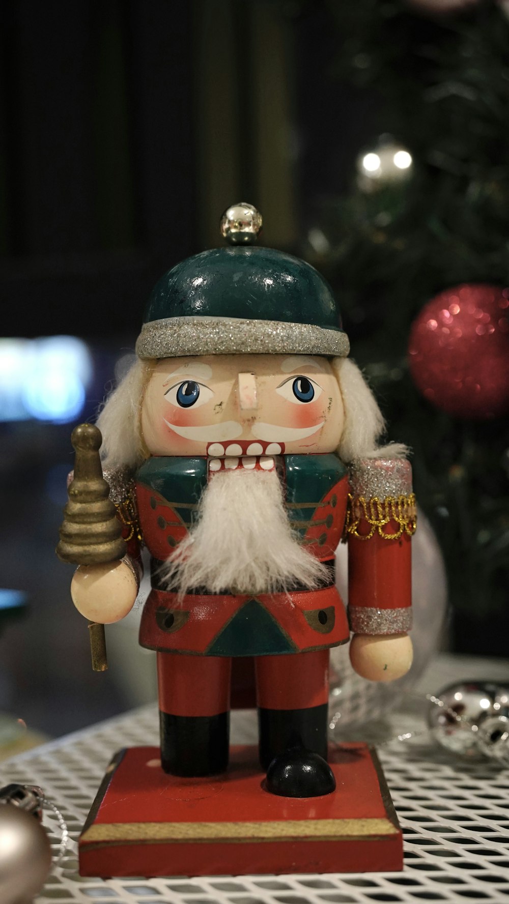 a nutcracker figurine on a table next to a christmas tree