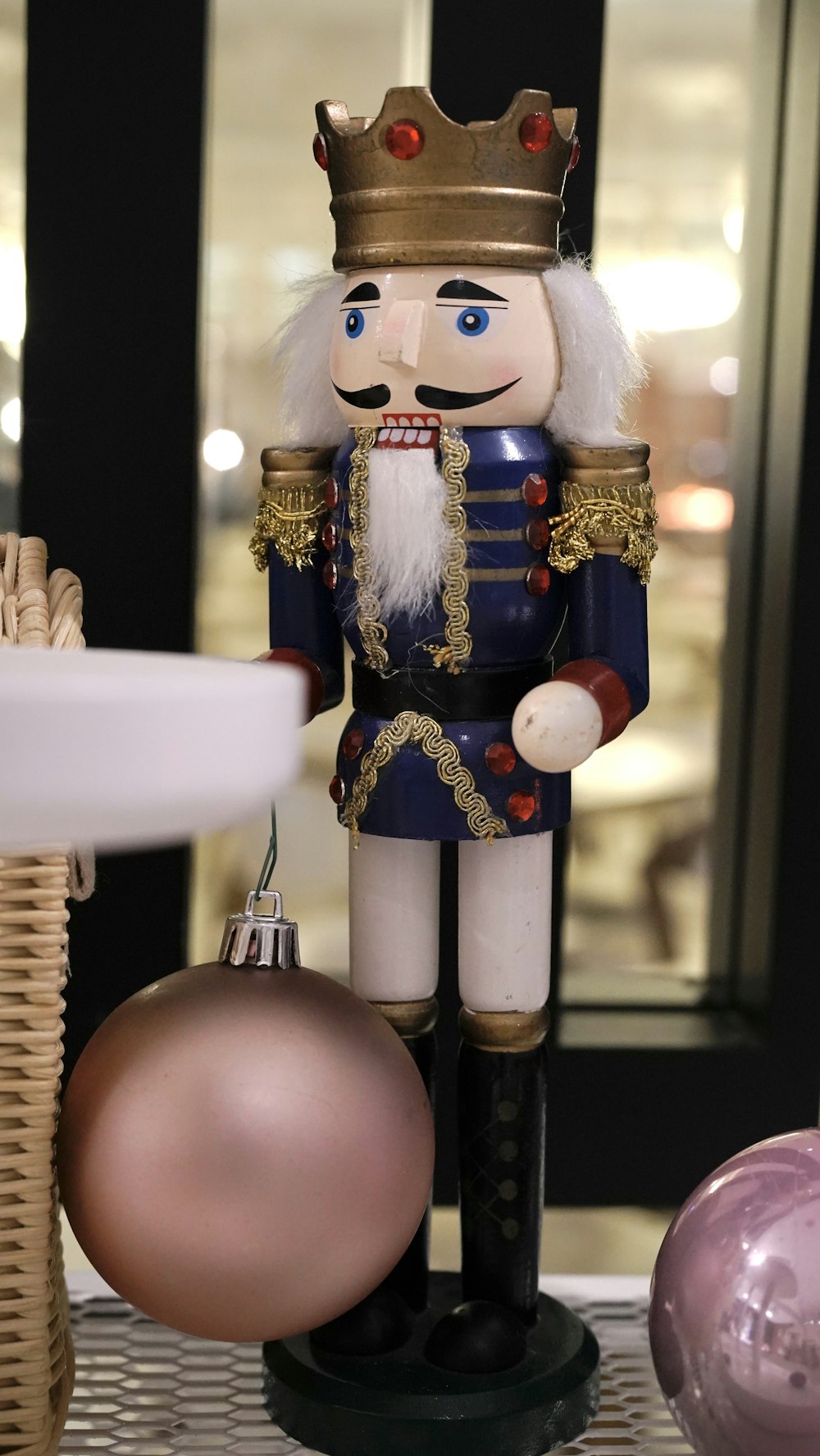 a nutcracker is standing next to a christmas ornament