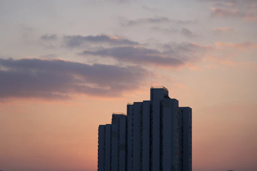 Avida Towers high-rise building against a sunset sky.
