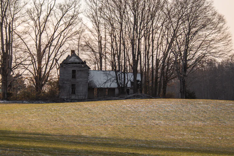 Old farmhouse standing in an open field