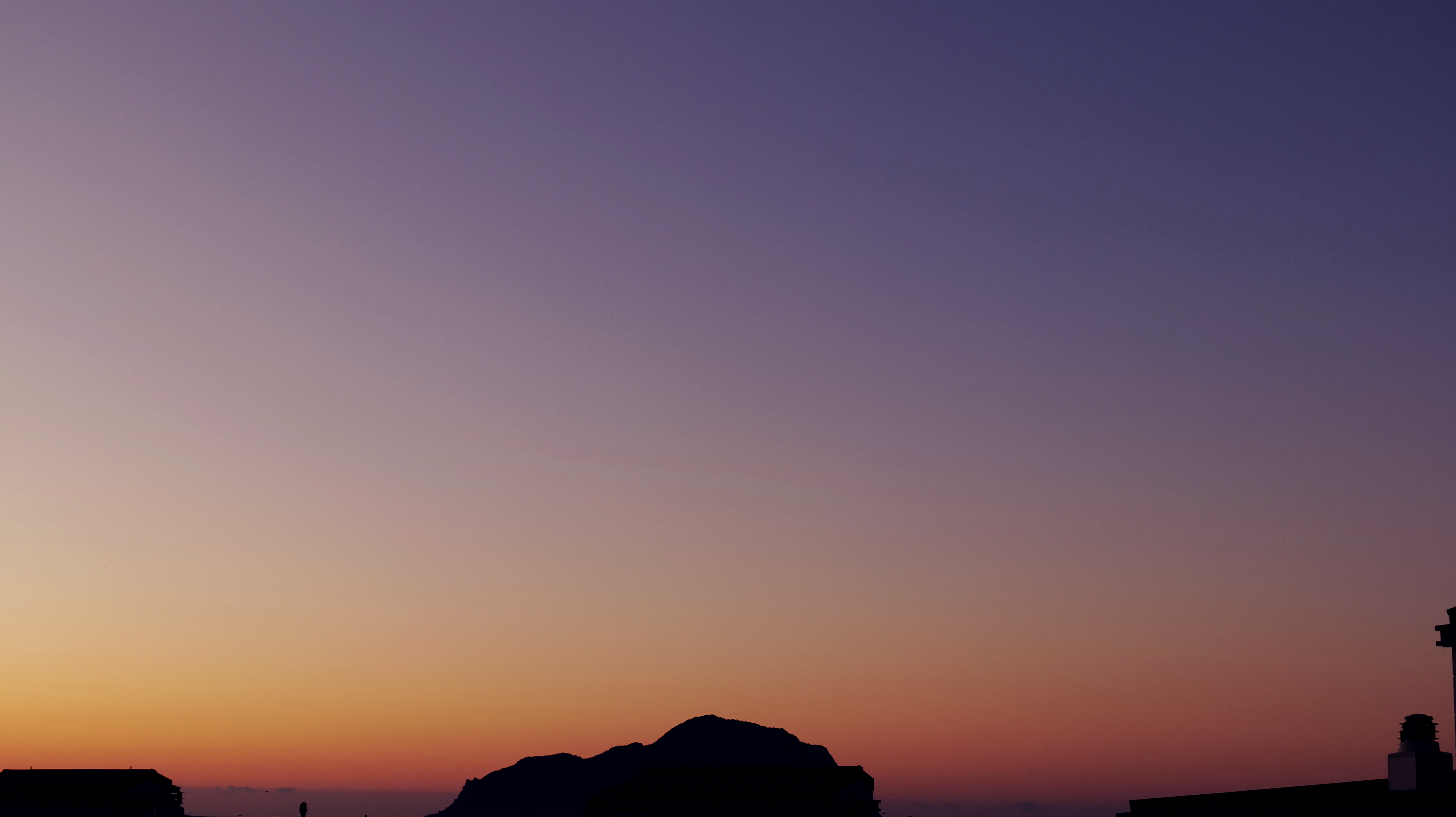 a plane flying in the sky at sunset