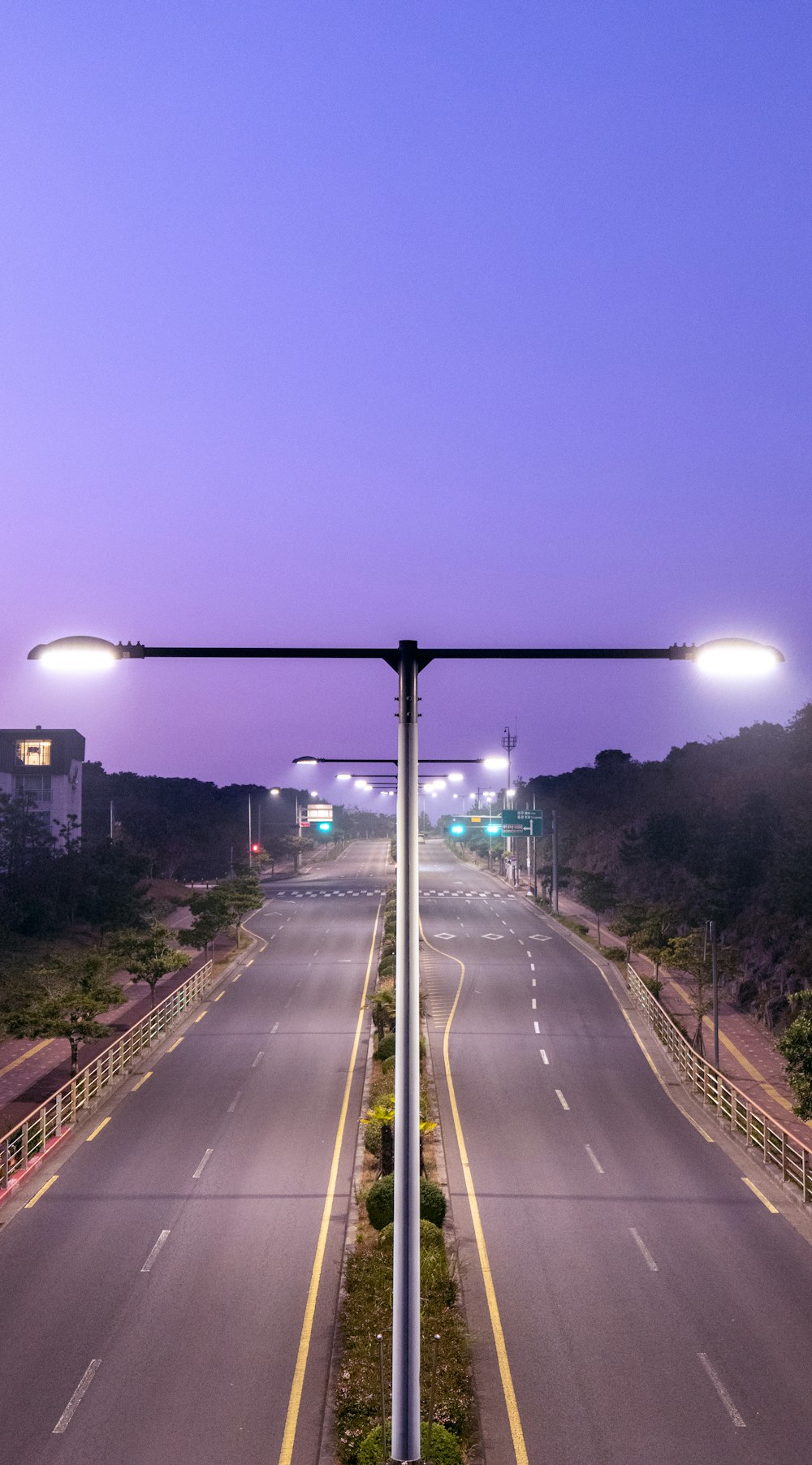 an empty street with a street light on the side of it