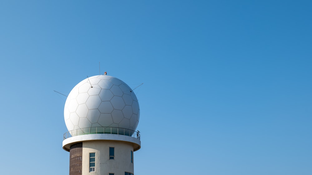 a white and black tower with a sky background