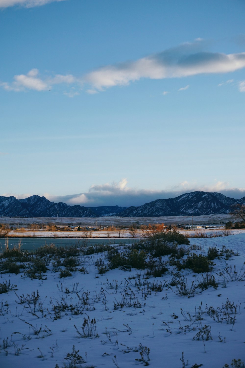 a snow covered field with mountains in the background