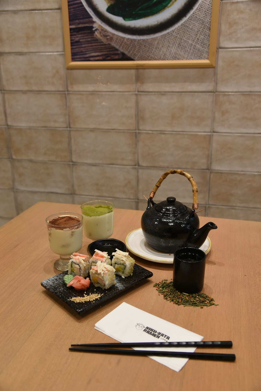 a wooden table topped with sushi and chopsticks