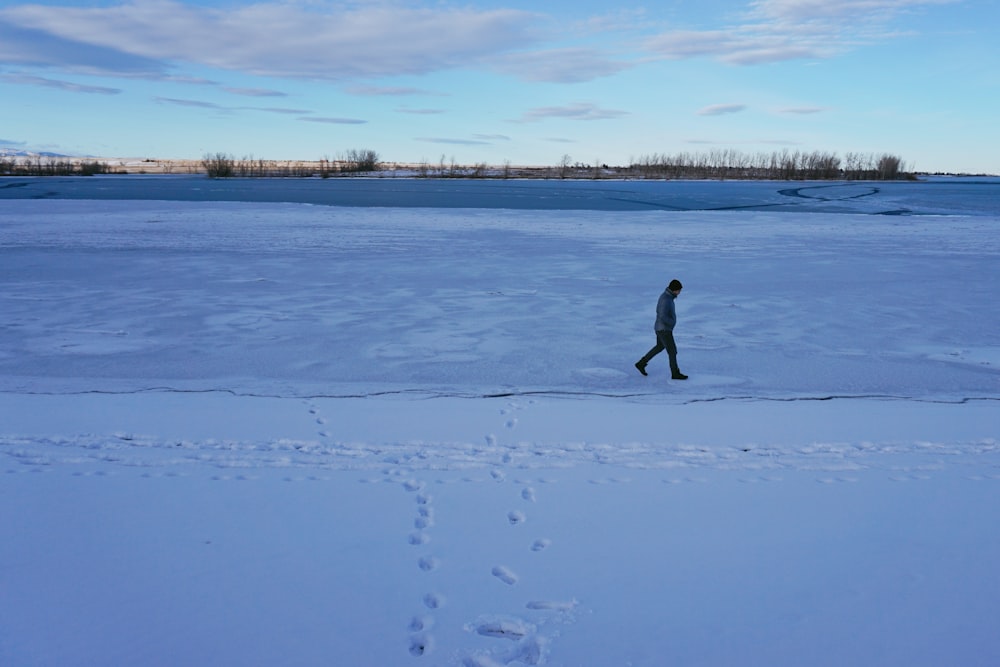 a person walking across a snow covered field