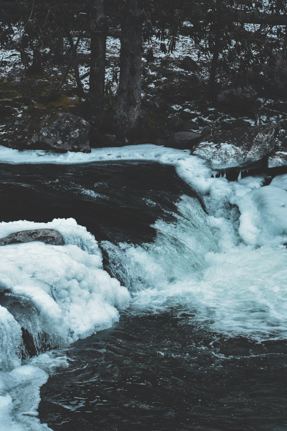 a man standing on a rock next to a waterfall