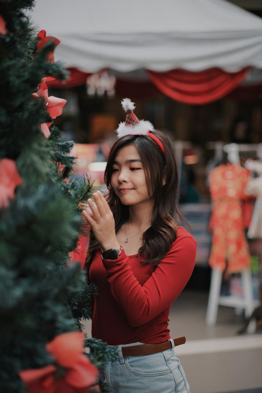 a woman standing next to a christmas tree