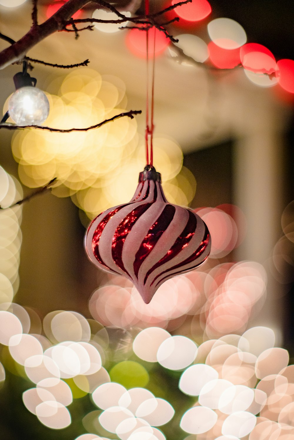 a red and white ornament hanging from a tree