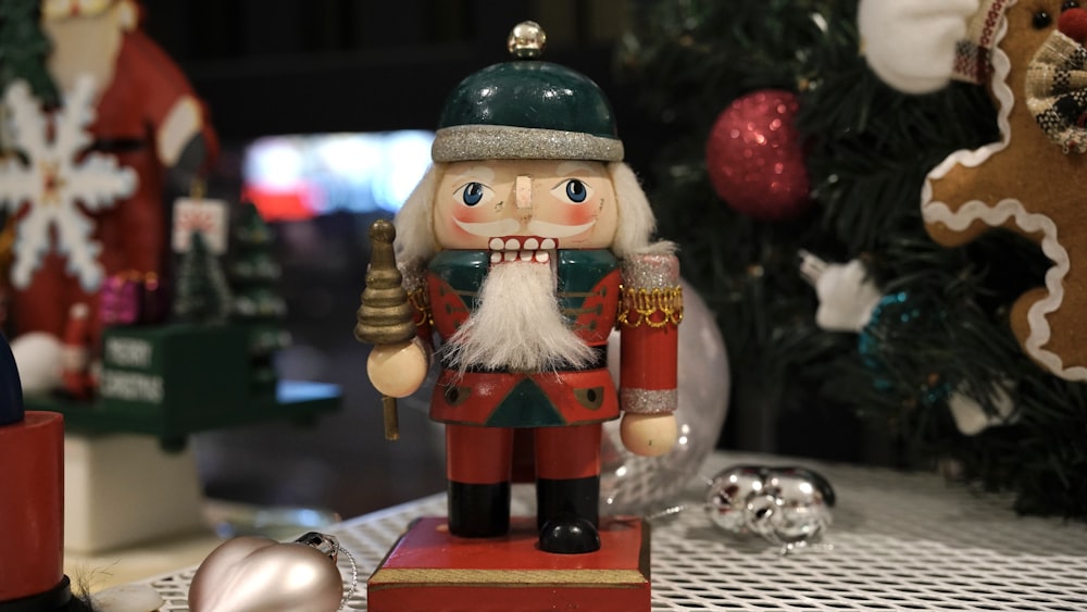 a nutcracker figurine with a christmas tree in the background