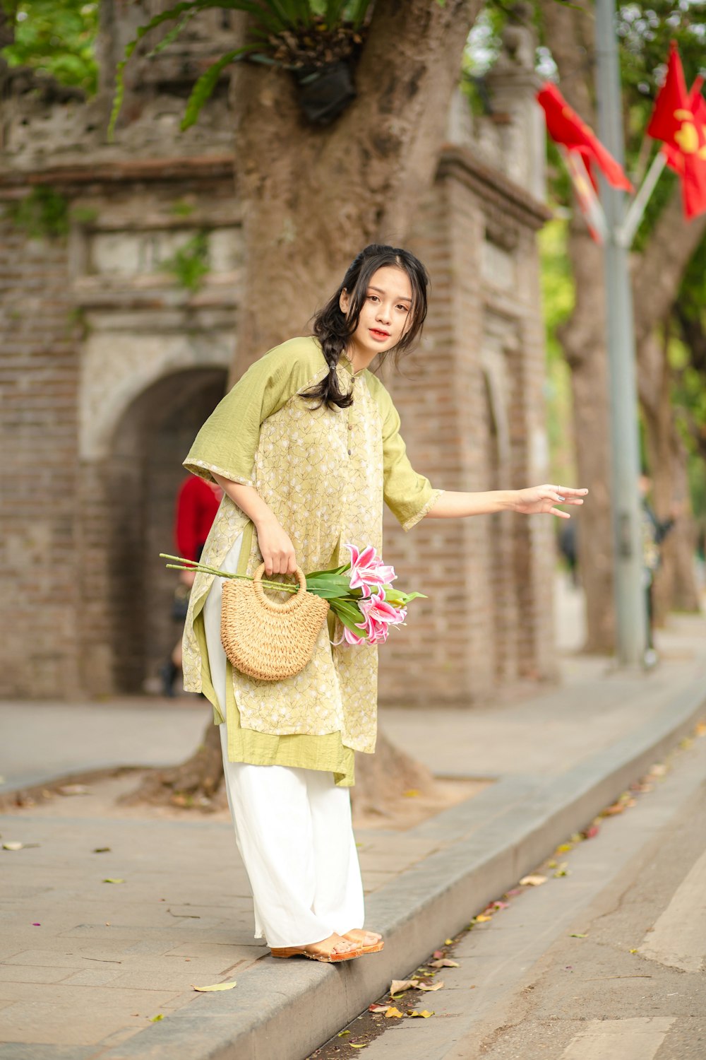 a woman is walking down the street with a basket of flowers