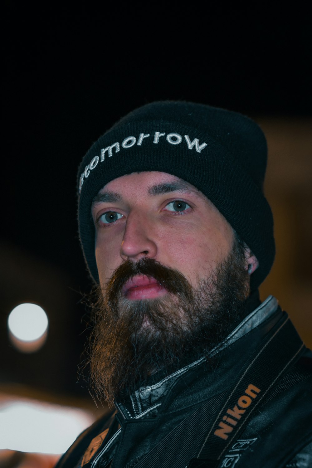 a man with a beard wearing a black hat