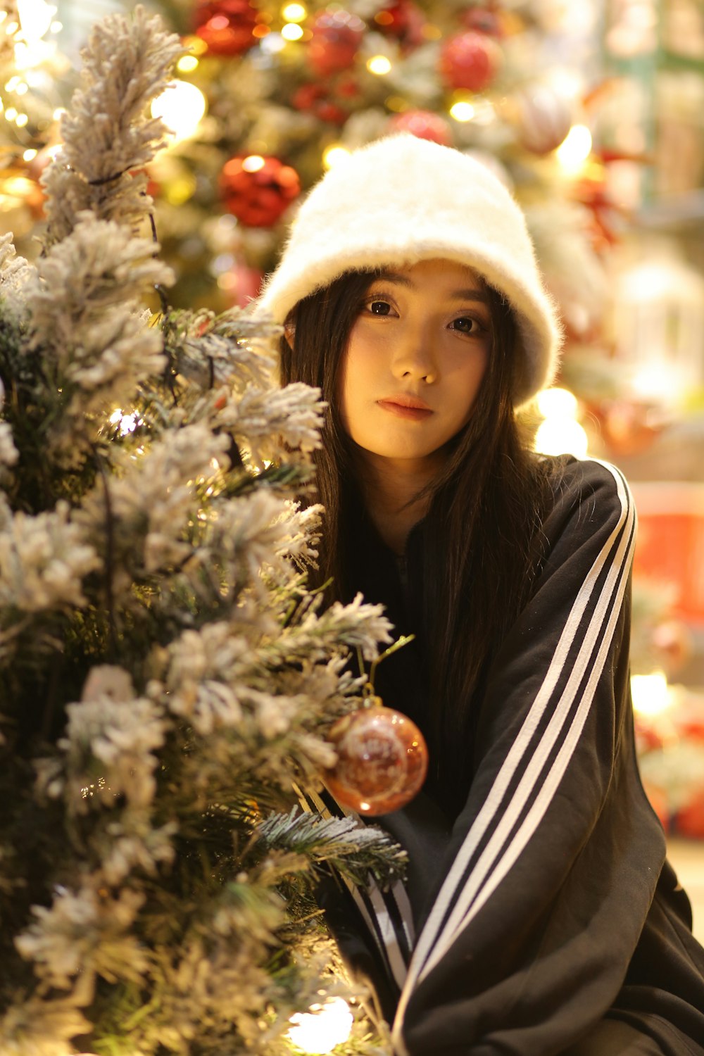 a young woman is leaning against a christmas tree