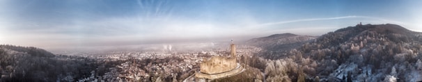 A panoramic view of the medieval castle of Belmonte under a bright blue sky.