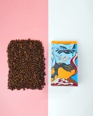 a box of coffee next to a bag of coffee beans