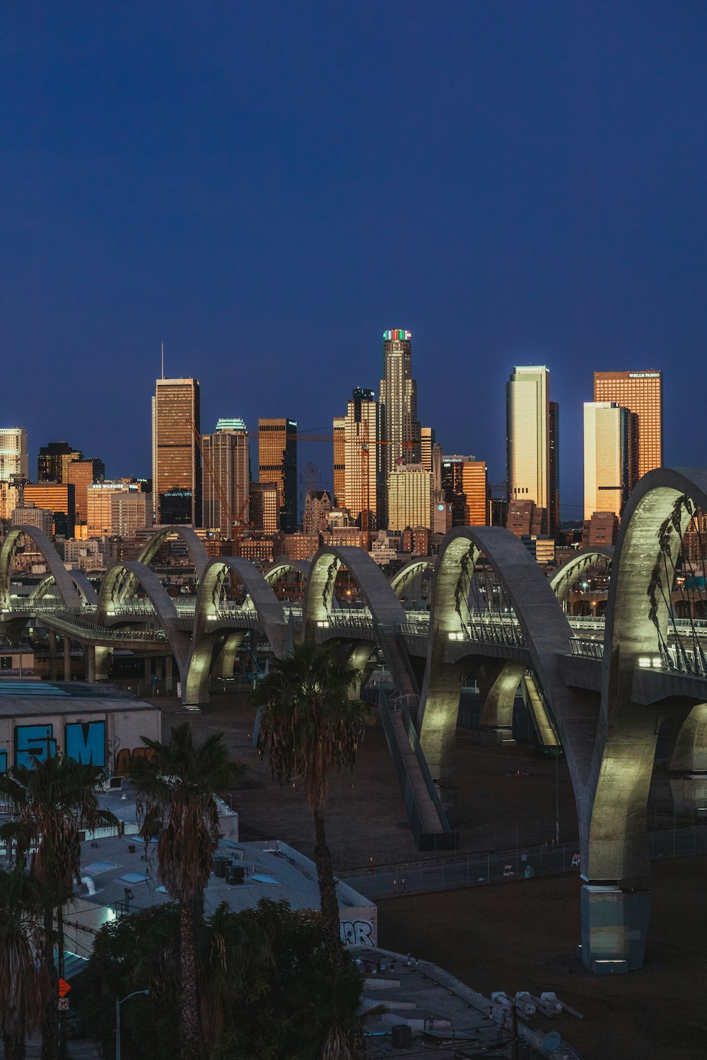 a city skyline with a bridge and palm trees