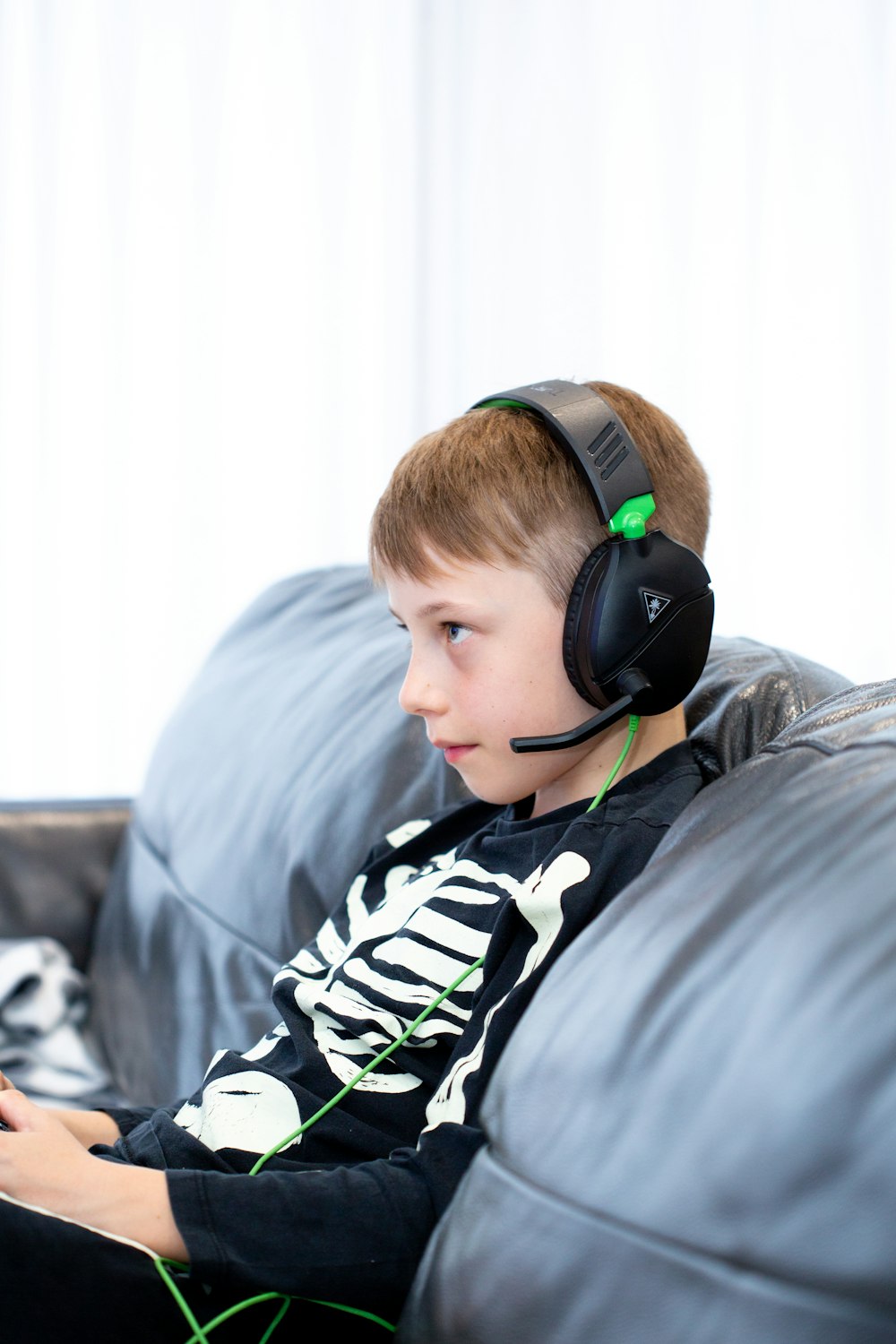 a young boy wearing headphones sitting on a couch