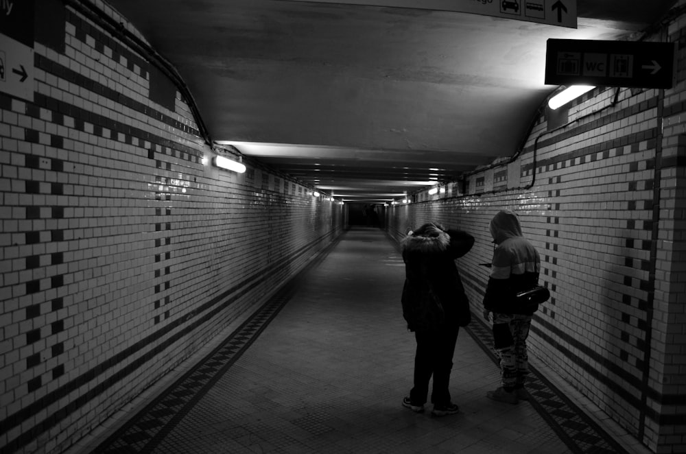 a couple of people that are standing in a tunnel