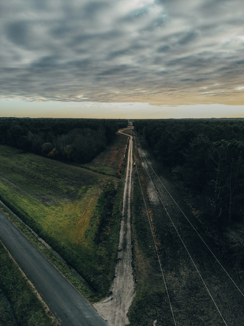 an aerial view of a road in the middle of a field