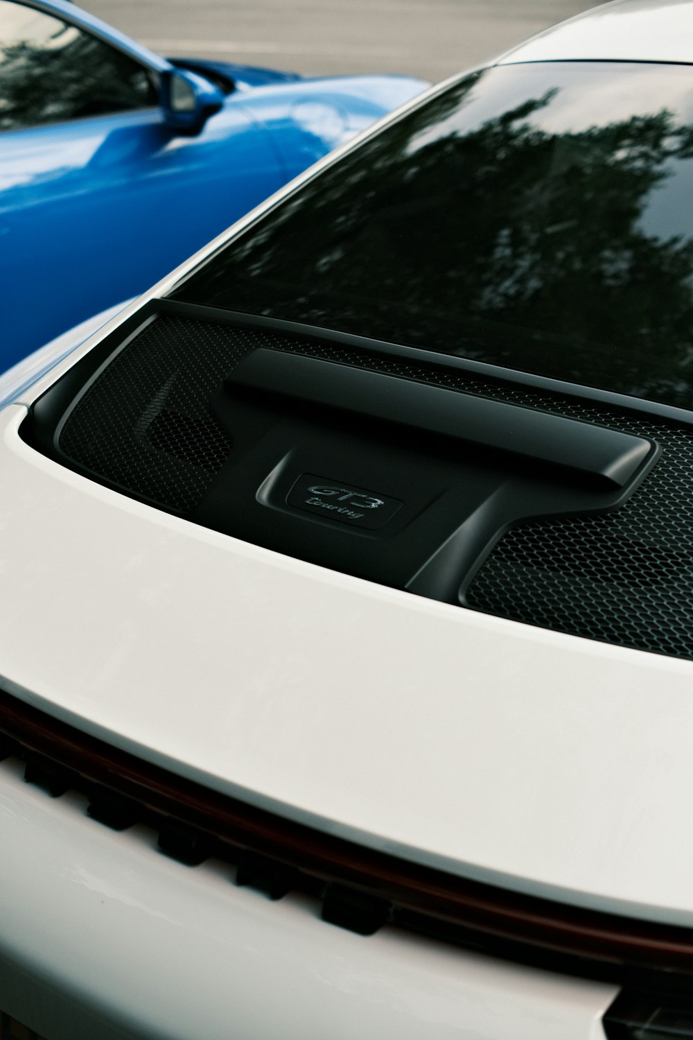 a white sports car parked next to a blue sports car