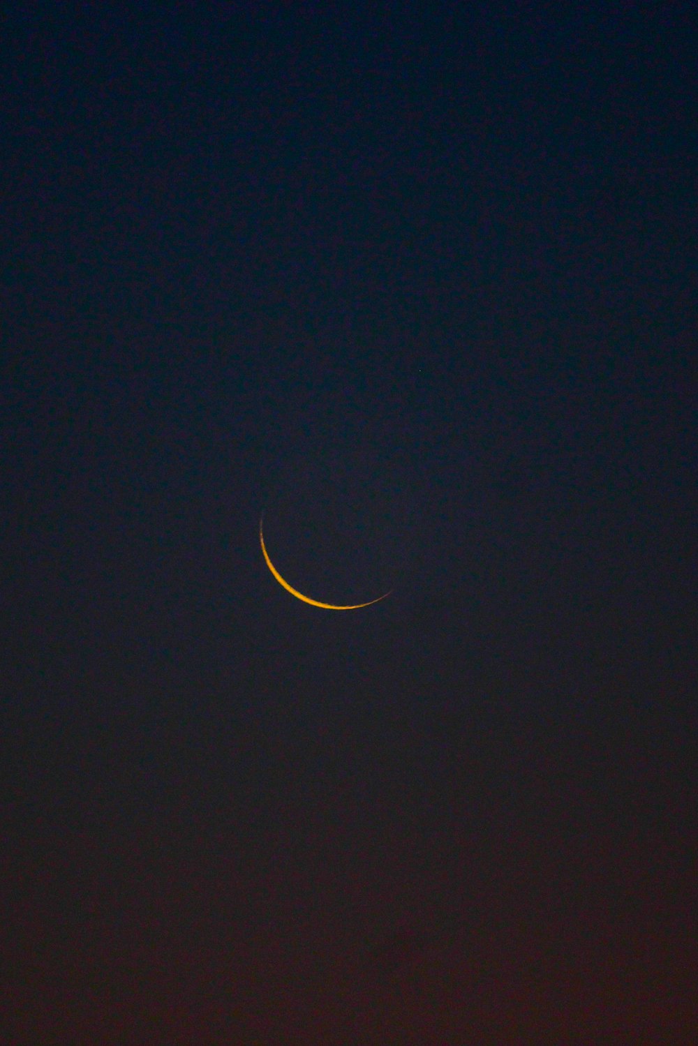 a crescent moon is seen in the night sky