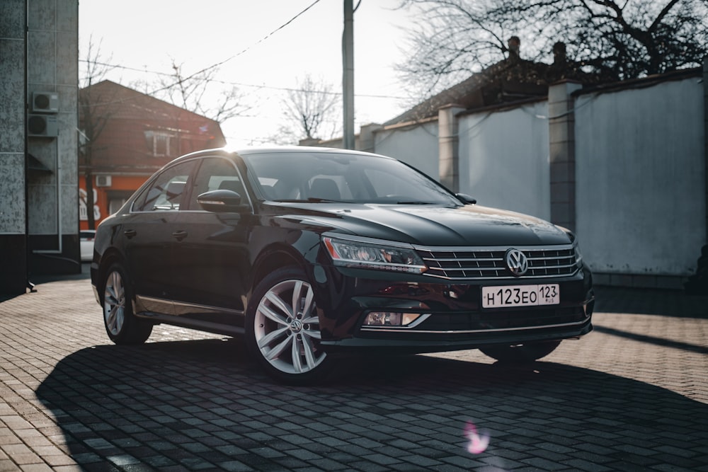 a black car parked on a brick road