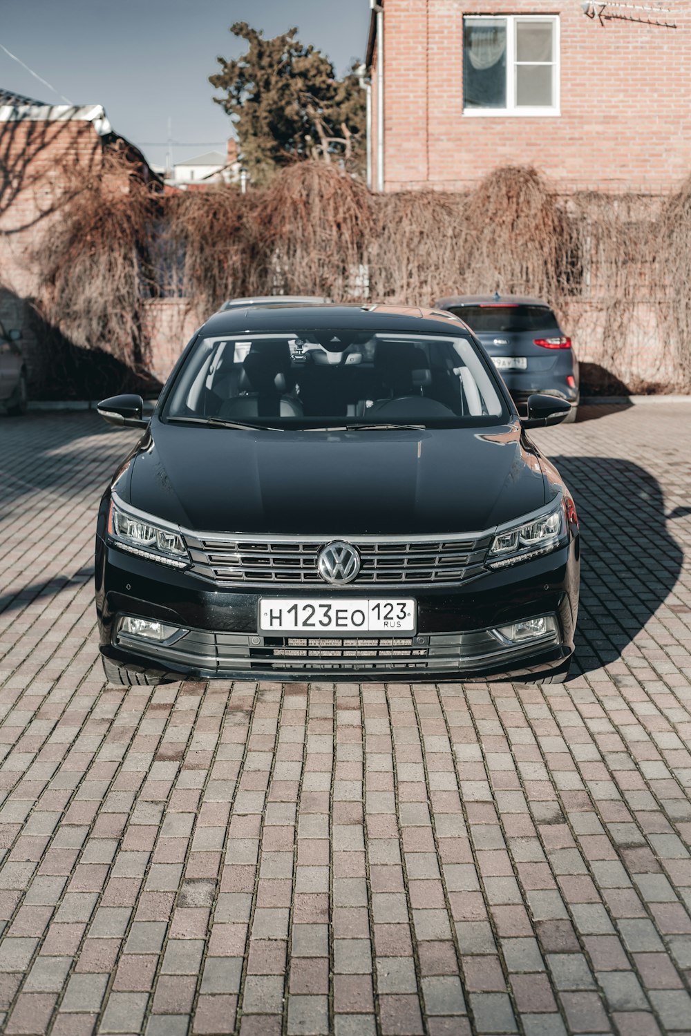 a black car is parked in a driveway