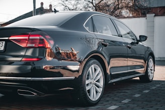 A sleek sedan gleaming under sunlight after a thorough exterior and interior detail.