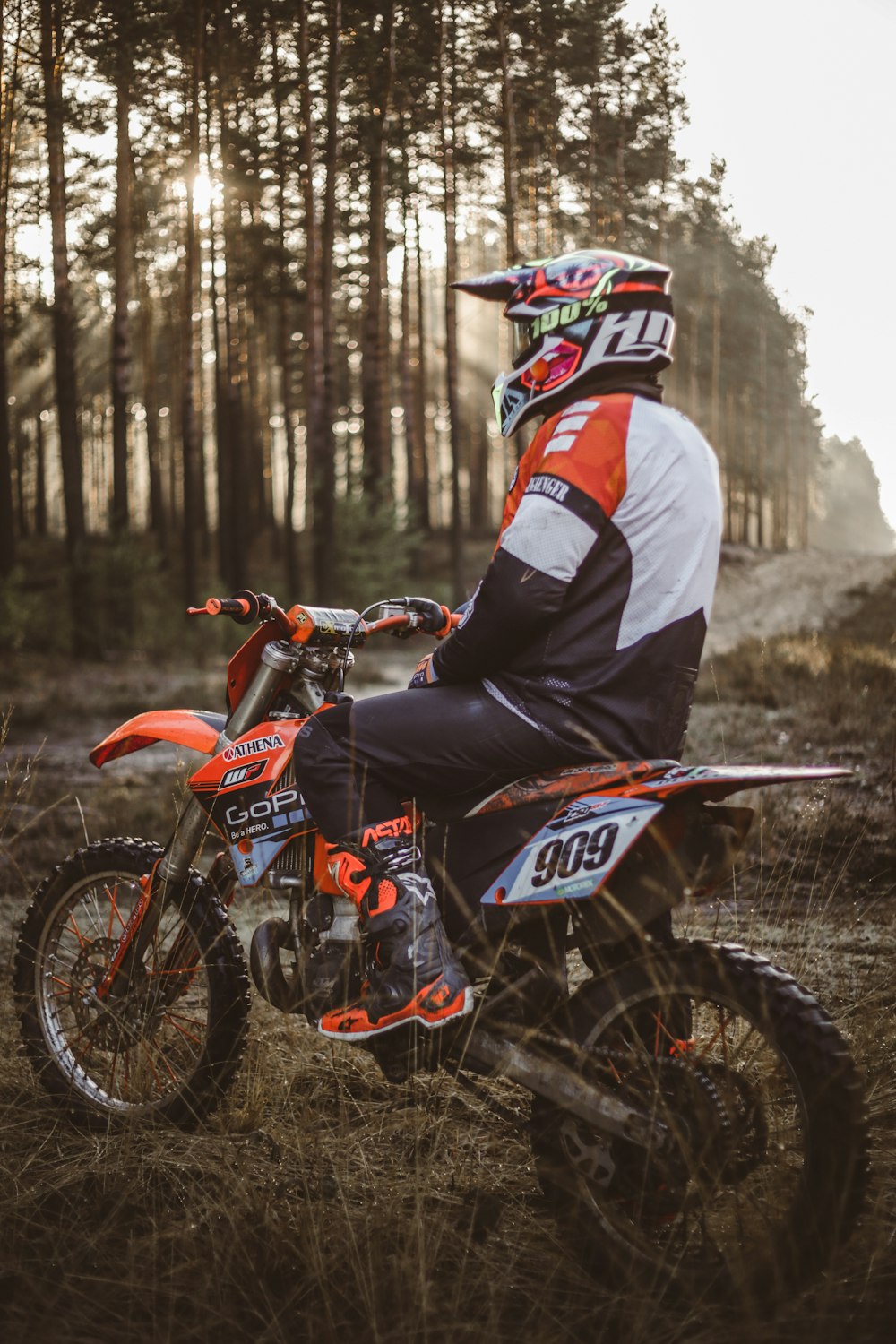 a man sitting on a dirt bike in the woods