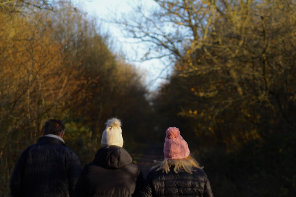 a man and a woman walking down a path in the woods