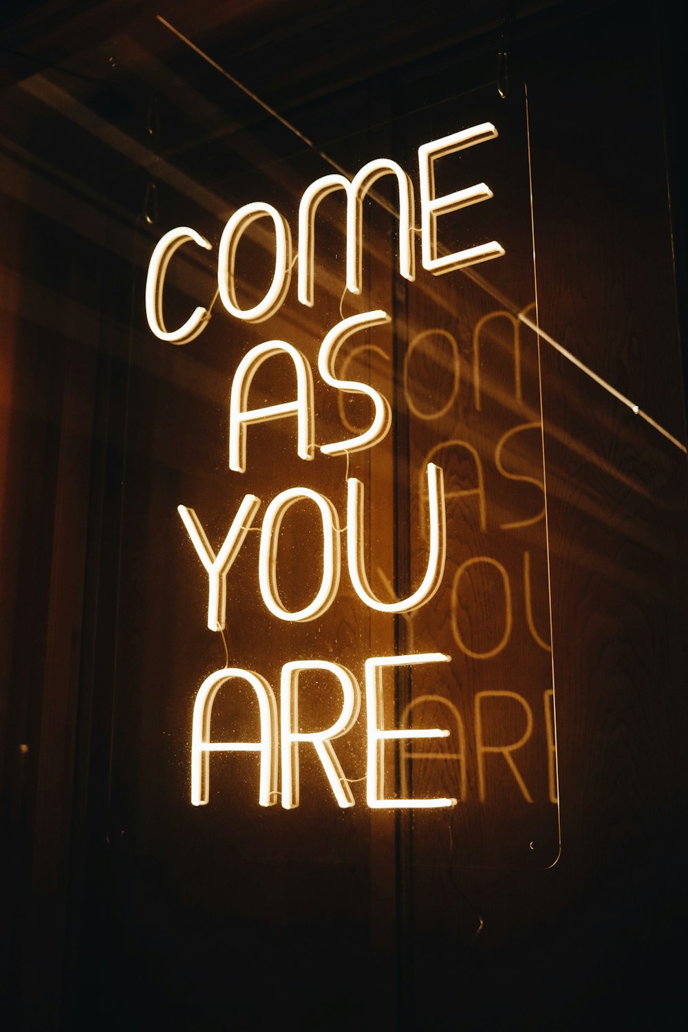 a neon sign that says come as you are