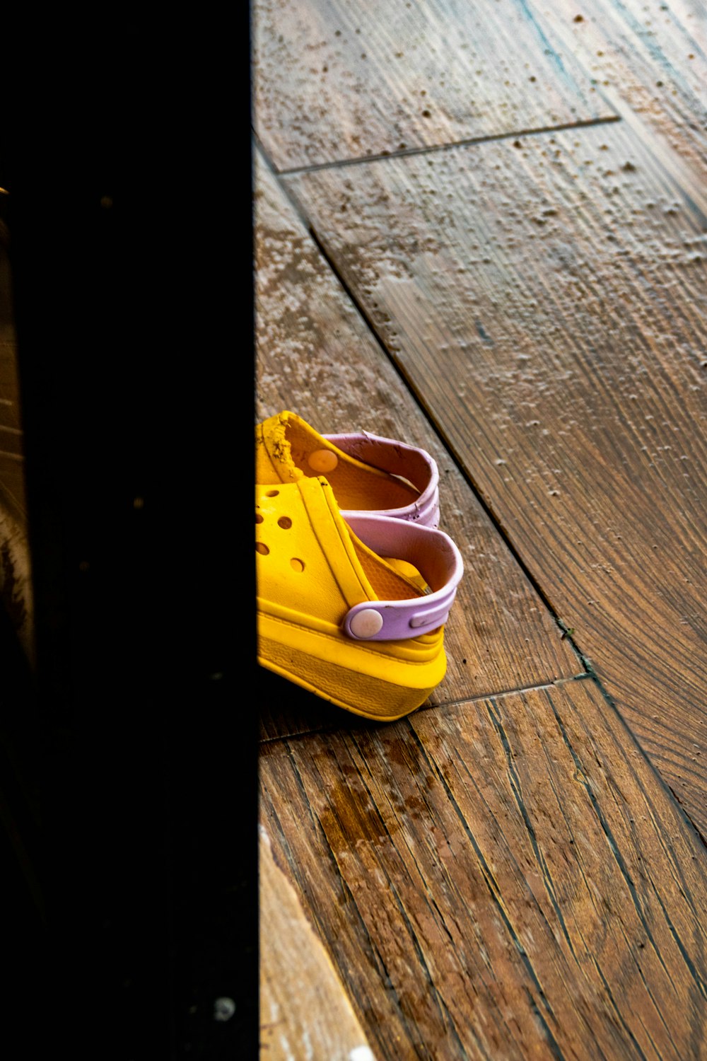 a pair of yellow shoes sitting on top of a wooden floor