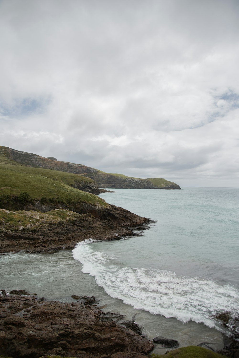 a body of water sitting on top of a lush green hillside