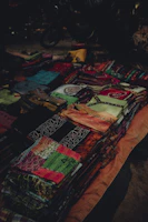 Close-up of colorful African fabrics neatly folded on a wooden table.
